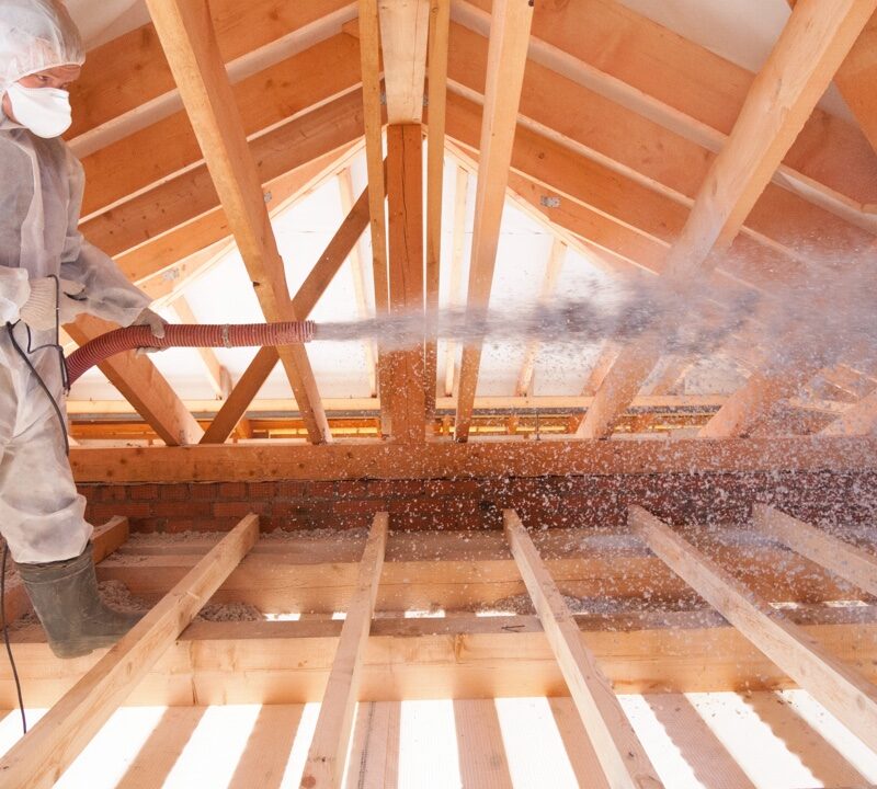 blowing in insulation into a framed attic of a house